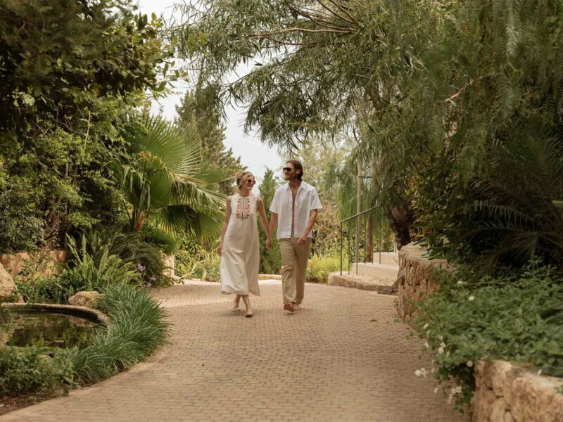 man and woman enjoying walk on hotel pathway surrounded by trees