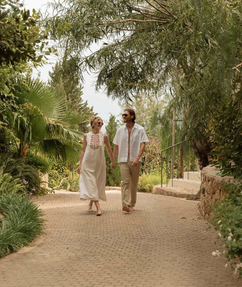 man and woman enjoying walk on hotel pathway surrounded by trees
