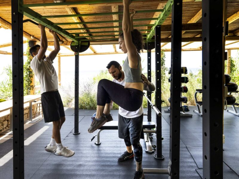 a woman and a man exercising on an outdoor gym