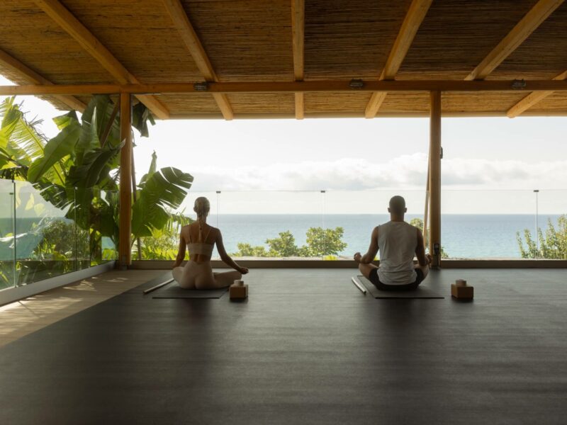 a couple doing yoga with sea view