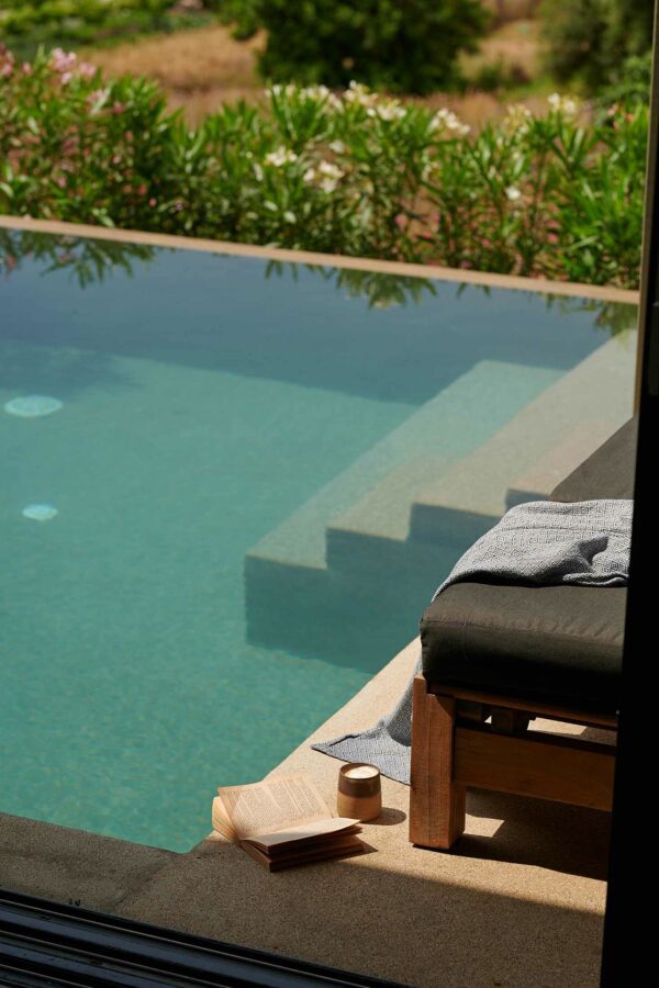view showing outside of luxurious pool with book and coffee